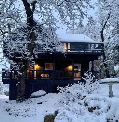 a log cabin in the snow with lights on at Charming Getaway Cabin in Lake Arrowhead