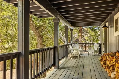 a wooden porch with rocking chairs on a house at Charming Getaway Cabin in Lake Arrowhead