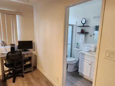 a bathroom with a desk with a computer and a toilet at Cozy Private Room & Bath Central Location LA in Los Angeles