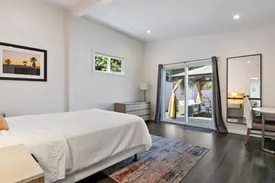 a bedroom with a bed and a table and a balcony at Lovely North Hollywood House Near Universal in North Hollywood