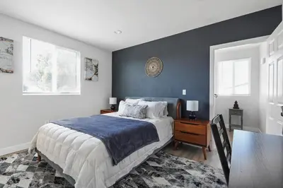 a bedroom with a large bed and a table at Good Shepard Homestay in Los Angeles