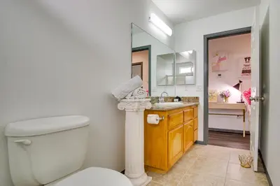 a bathroom with a toilet and a sink and a mirror at Family Helendale Home - Private Dock and Fire Pit! in Helendale