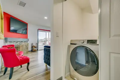 a living room with a red chair and a washing machine at Family Helendale Home - Private Dock and Fire Pit! in Helendale