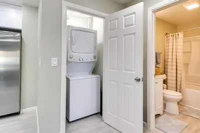a bathroom with a washer and dryer next to a door at Fast WiFi and Free Parking Cozy Fontana Apartment in Fontana