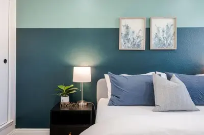 a bedroom with a blue accent wall and a bed at Elegant Retreat w/ Game room in Heart of OC in Midway City