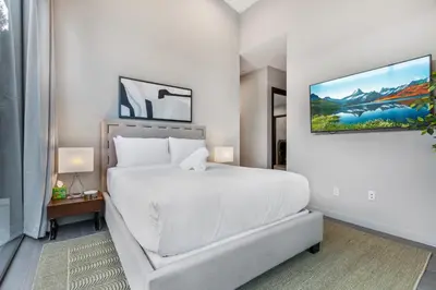 a white bedroom with a large bed and a tv at Coldwater Canyon in Los Angeles