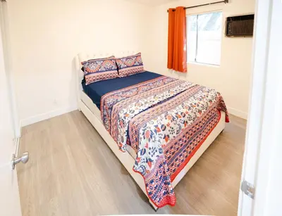 a bedroom with a bed with a comforter and a window at cozy small 2 bedroom in Koreatown/Hollywood in Los Angeles