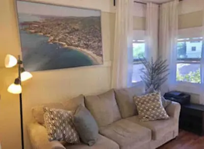 a living room with a couch and a painting on the wall at Urban Oasis with Private Laundry: Steps from DTLA in Los Angeles
