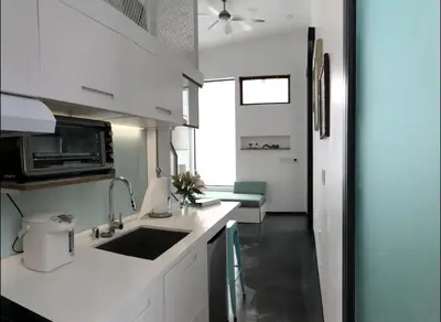 a white kitchen with a sink and a microwave at Dogtown Loft in Los Angeles