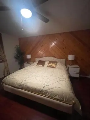 a bedroom with a large bed with a wooden headboard at Beautiful, family friendly cabin by Lake Gregory. in Crestline