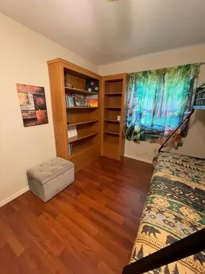 a bedroom with a bed and a wooden floor at Beautiful, family friendly cabin by Lake Gregory. in Crestline