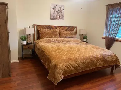 a large bed in a bedroom with two lamps on tables at Beautiful, family friendly cabin by Lake Gregory. in Crestline