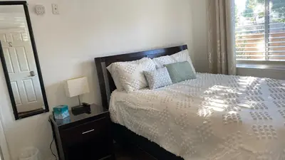 a bedroom with a bed and a mirror and a window at Buxton Room in Rialto