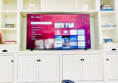 a large flat screen tv on top of a white cabinet at 2 BR 2 BA - Eco House and Garden Vacation Retreat and Remote Workspace for Families, Couples and Solo Travelers in Coveted Culver in Culver City