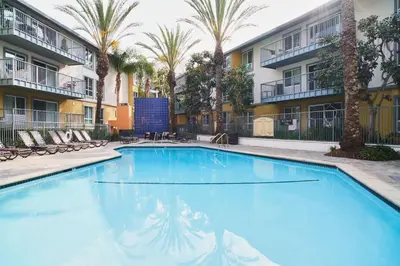 a large swimming pool with palm trees and buildings at Amber Tide - Bright 1BR Marina Gem Ocean View in Los Angeles