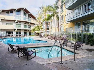 a swimming pool with chairs and a building at Amber Tide - Bright 1BR Marina Gem Ocean View in Los Angeles