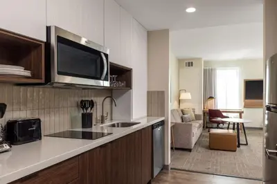 a kitchen with a sink and a living room at Staybridge Suites Eastvale - Norco by IHG in Eastvale