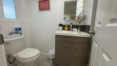 a white bathroom with a toilet and a sink at AB&B suite in Chino Hills