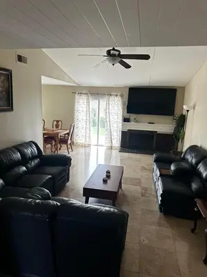 a living room with black leather couches and a table at Buxton Mirror Room in Rialto