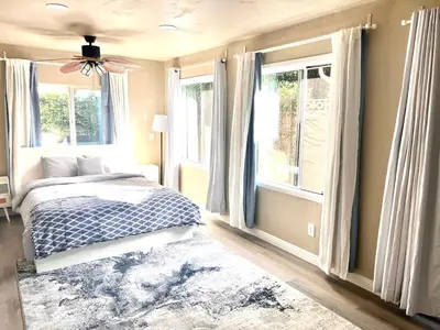 a bedroom with a bed and two windows at Cozy Room with Private bathroom & Entrance in Carson