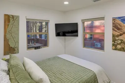 a bedroom with a bed and a flat screen tv at Cozy Wrightwood Cabin Family and Pet Friendly! in Wrightwood
