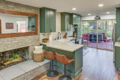a kitchen with green cabinets and a fireplace at Cozy Wrightwood Cabin Family and Pet Friendly! in Wrightwood