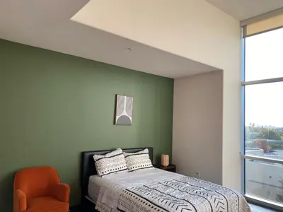 a green bedroom with a bed and an orange chair at Spacious and Stylish unit in Los Angeles