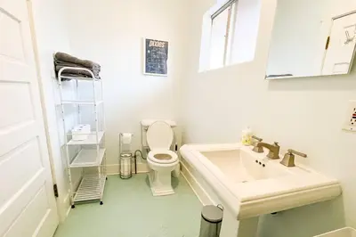 a white bathroom with a toilet and a sink at Peaceful 1BR Suite, Yurt and Barn in Cypress Park in Glendale