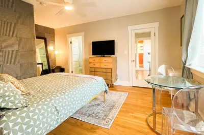 a bedroom with a bed and a television and a table at Peaceful 1BR Suite, Yurt and Barn in Cypress Park in Glendale