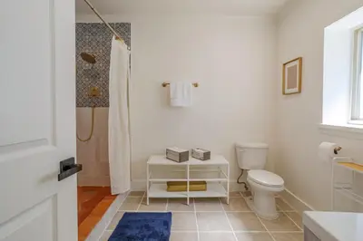 a white bathroom with a toilet and a shower at Elegant Guest unit Universal sleeps 6 hot tub in Los Angeles