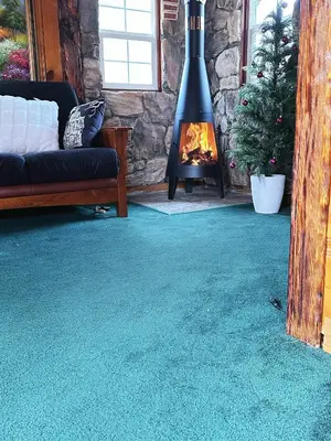 a living room with a fireplace and a green carpet at 1 B1B lake cabin/walk to lake/Boulder bay park in Big Bear Lake