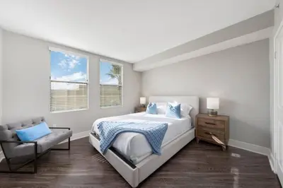 a white bedroom with a bed and a chair at Blue Topaz Retreat - Spacious 3BR Gorgeous City views in Los Angeles