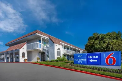 a building with a sign in front of it at Studio 6 Suites Carpinteria, CA Santa Barbara South in Carpinteria