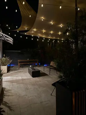 a patio at night with a bench and lights at Resort Getaway in Private Garden Terrace Villa w Luxury Amenities in Los Angeles