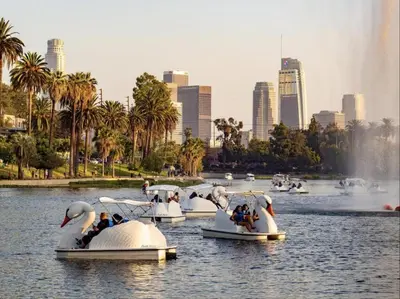 a group of people riding onlatable swans in the water at Resort Getaway in Private Garden Terrace Villa w Luxury Amenities in Los Angeles