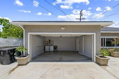 a garage with two potted plants in front of a house at Stylist Home In Convenient Location! in Temple City