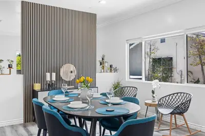 a dining room with a table and blue chairs at Stylist Home In Convenient Location! in Temple City