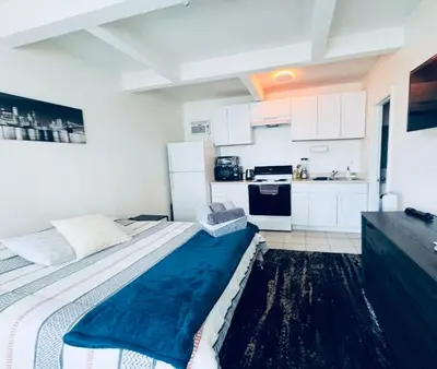 a bedroom with a large bed and a kitchen at Wonderful LA studio apartment in Los Angeles