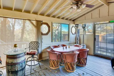 a room with a table and chairs and windows at Spacious Crestline Retreat 1 Mi to Lake Gregory in Crestline