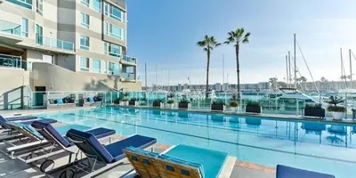 a swimming pool with chairs and a building at The Coral Loft - Marina Bliss Water view 2BR Pool, Gym in Los Angeles