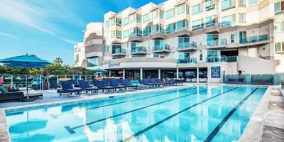 a hotel swimming pool with chairs and a building at The Coral Loft - Marina Bliss Water view 2BR Pool, Gym in Los Angeles