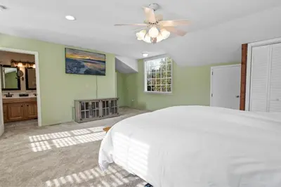 a bedroom with a white bed and a ceiling fan at Serene Lakefront Haven by Rather Be Properties in Big Bear Lake