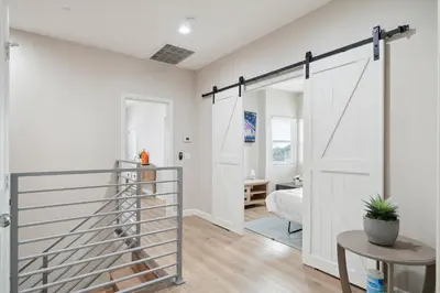a pivot door in a room with a bedroom at Amazing Value with High Comfort, 14 Guests for 4BR by Disneyland, Beaches, Rodeo 39 & More in Midway City