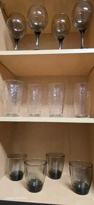 a row of glasses and wine glasses on shelves at Large two-room apartment near LAX and the Ocean in Los Angeles