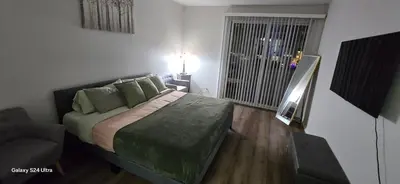 a bedroom with a bed and a chair and a window at Large two-room apartment near LAX and the Ocean in Los Angeles