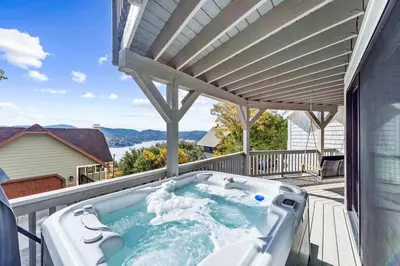 a hot tub on the balcony of a house at Majestic Lakeview Lodge in Lake Arrowhead