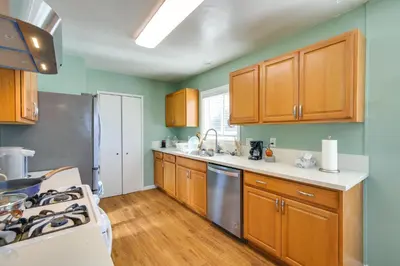 a kitchen with wooden cabinets and a stove top oven at Lakewood Home about 5 Mi to Knotts Berry Farm! in Lakewood
