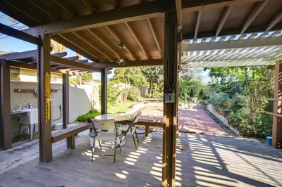 a wooden patio with a table and chairs on it at Lakewood Home about 5 Mi to Knotts Berry Farm! in Lakewood