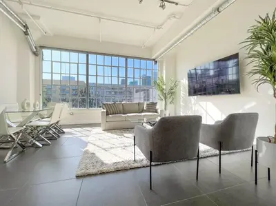 a living room with a couch and a table at Modern Loft in DTLA - Rooftop Pool & Free Parking! in Los Angeles