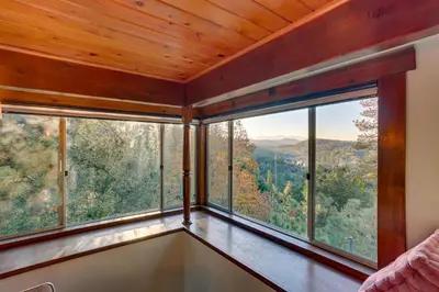 a room with large windows with views of the mountains at Crestline Cabin Mountain Views and Fire Pit! in Crestline